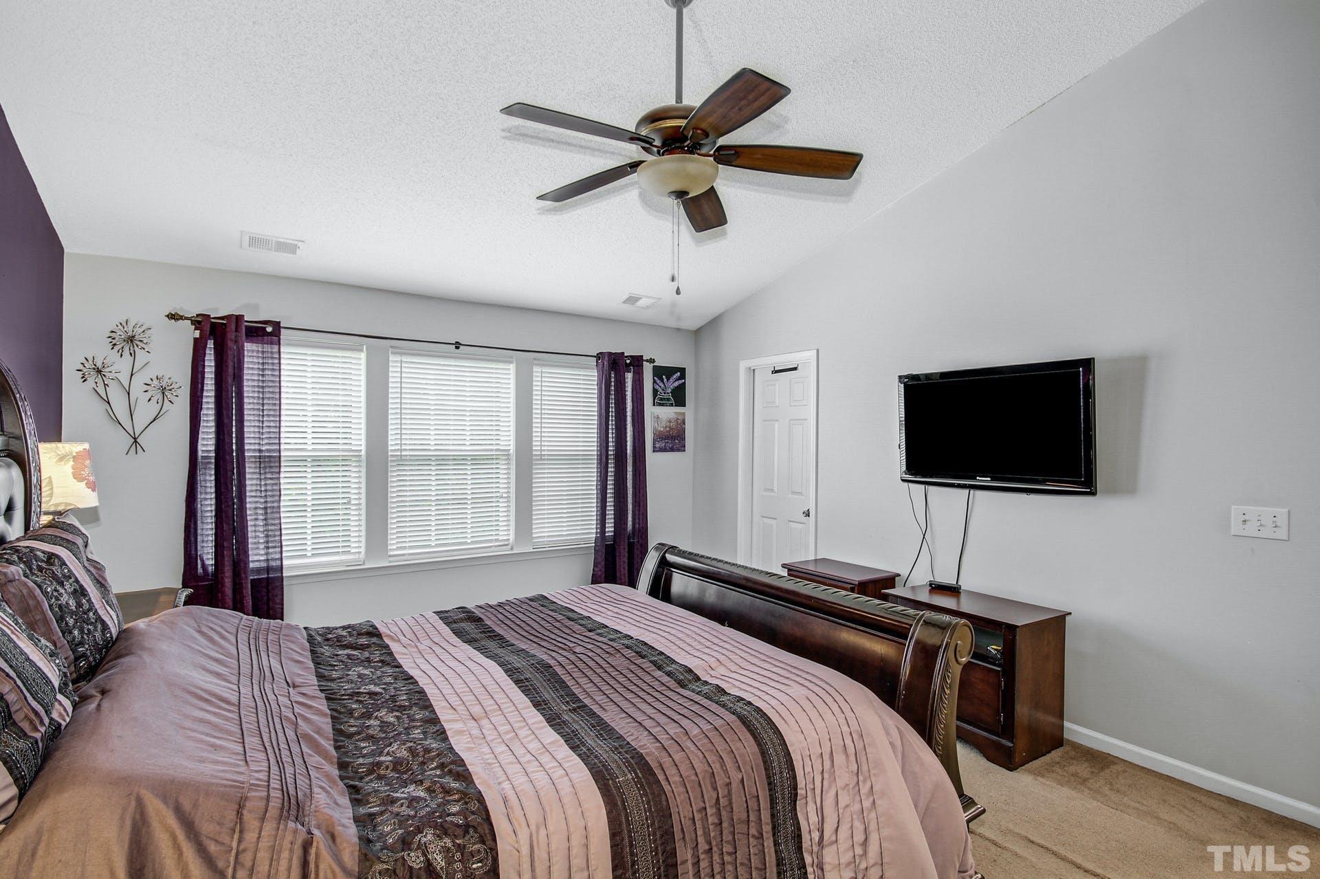 5925 Wessel Way Raleigh, NC 27610 - Photo 16 of 29 a bedroom with a bed and a flat screen tv