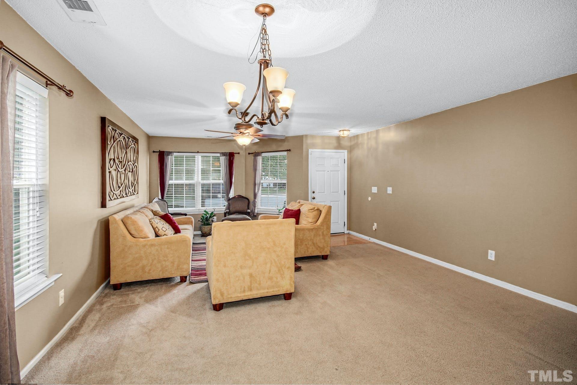 5925 Wessel Way Raleigh, NC 27610 - Photo 5 of 29 a living room with furniture and a chandelier