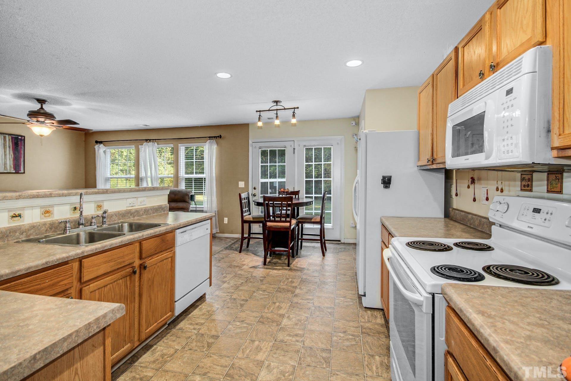 5925 Wessel Way Raleigh, NC 27610 - Photo 8 of 29 a kitchen with sink a stove and chairs
