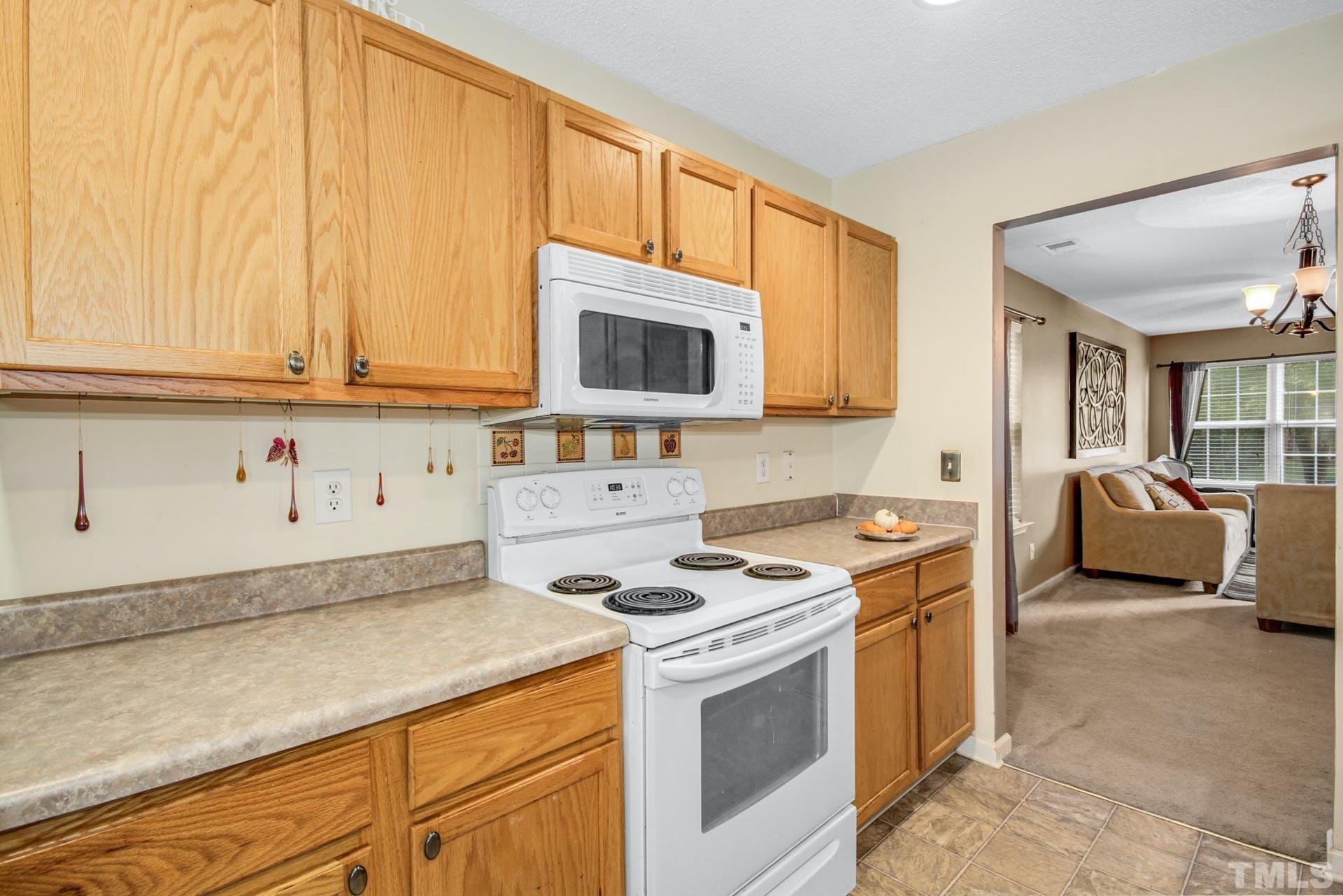 5925 Wessel Way Raleigh, NC 27610 - Photo 9 of 29 a kitchen with stainless steel appliances granite countertop a stove a sink and a microwave