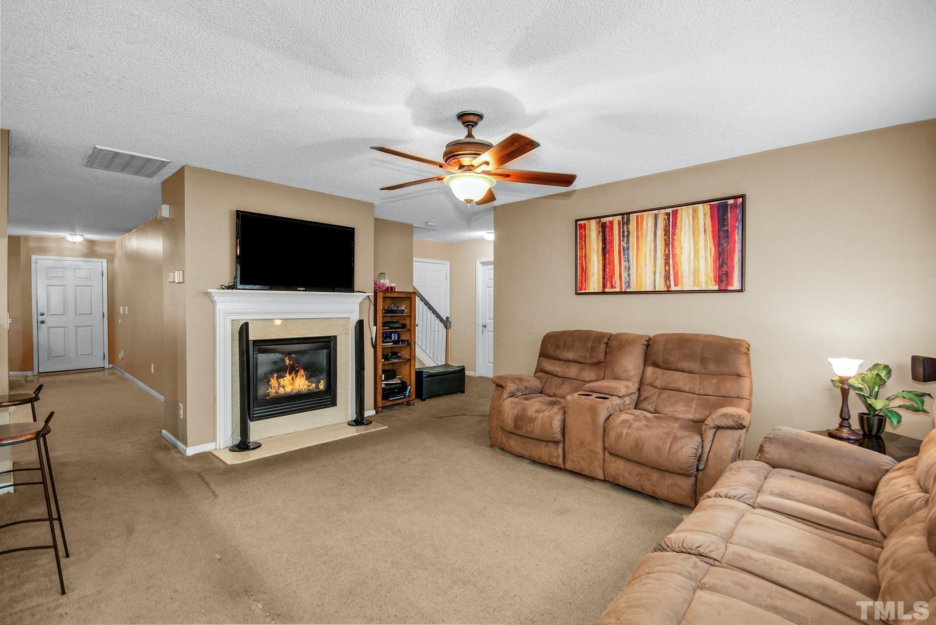 5925 Wessel Way Raleigh, NC 27610 - Photo 10 of 29 a living room with furniture a flat screen tv and a fireplace