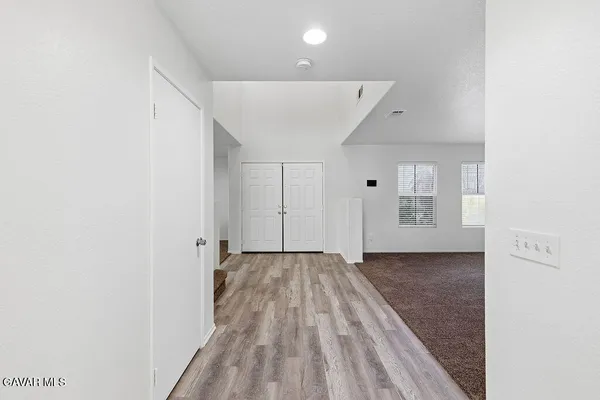 a large kitchen with a large counter top a sink stainless steel appliances and cabinets