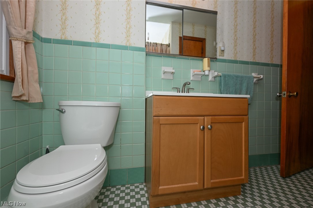 849 Bears Den Road Youngstown, OH 44511 - Photo 13 of 28 Bathroom with vanity with extensive cabinet space, mirror, backsplash, tile walls, and tile floors