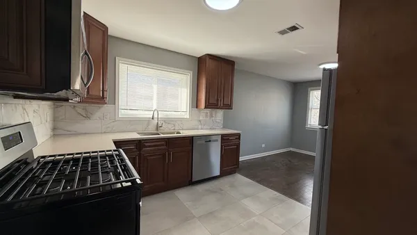 a kitchen with granite countertop a stove and a sink