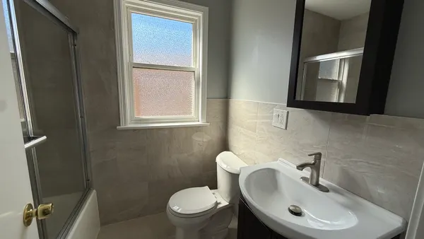 a bathroom with a toilet sink and mirror