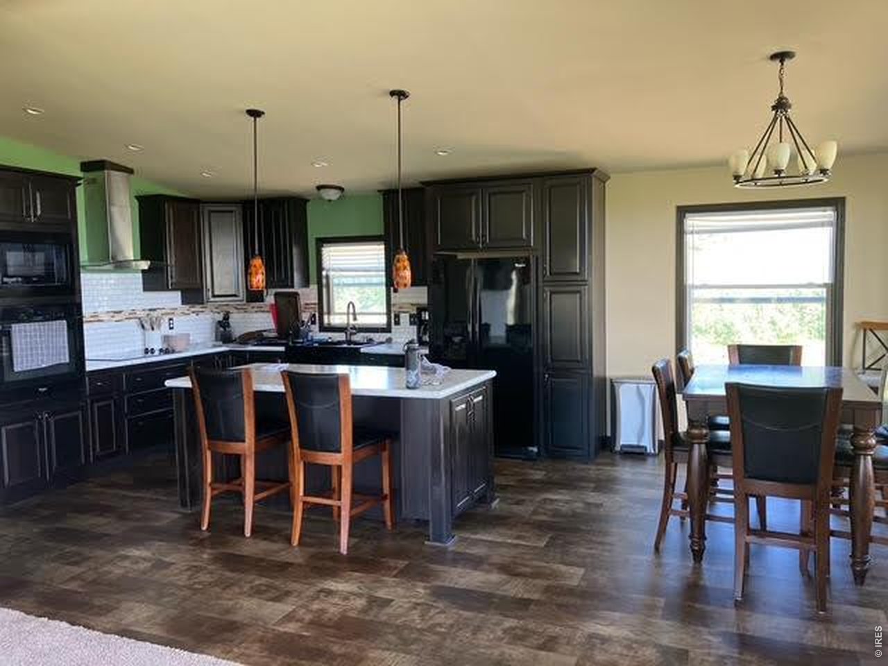 892 Stratton Park Road Bellvue, CO 80512 - Photo 3 of 27 a kitchen with a dining table chairs and granite counter tops