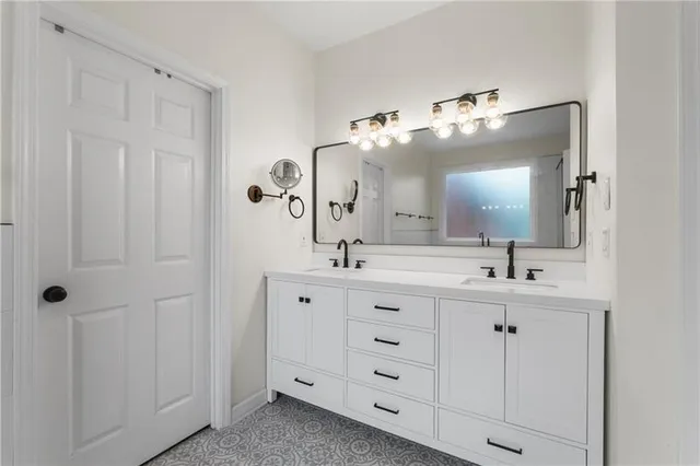 a bathroom with double vanity and a mirror