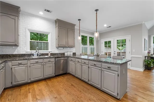 a kitchen with granite countertop a sink cabinets and window