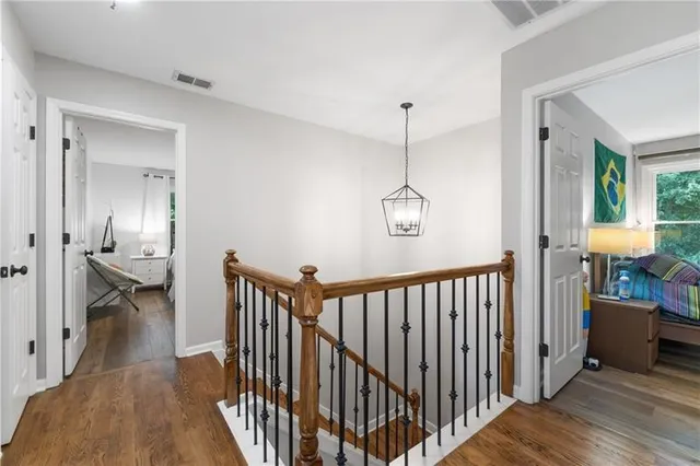 a view of a hallway with a livingroom and chandelier