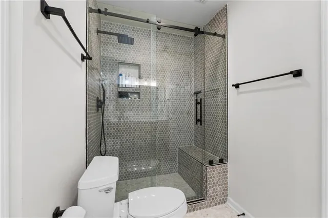 a bathroom with a toilet and a shower