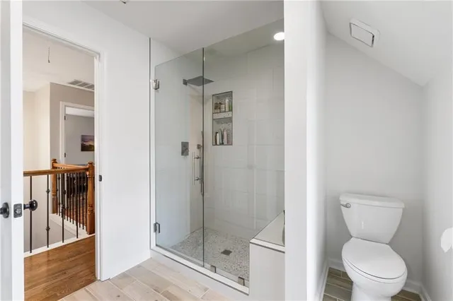 a bathroom with a toilet and a shower