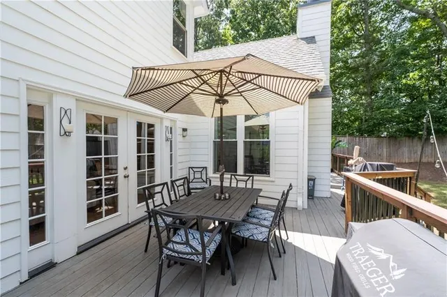 a view of a patio with table and chairs with wooden floor and fence
