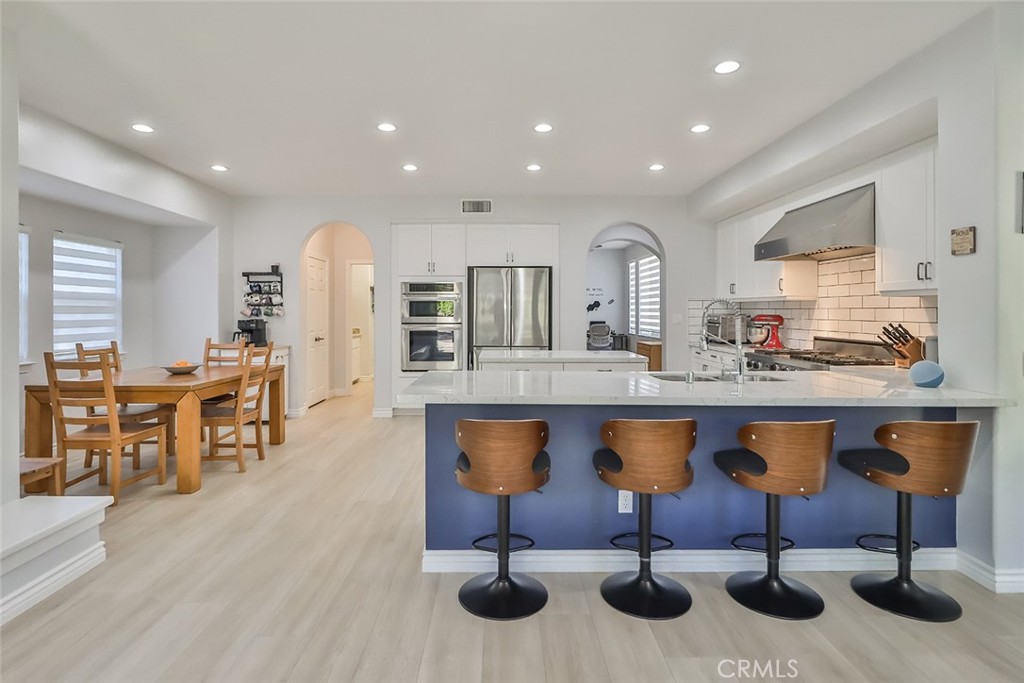 5421 Moonshadow Street Simi Valley, CA 93063 - Photo 16 of 56 a kitchen with stainless steel appliances granite countertop wooden floor and chairs