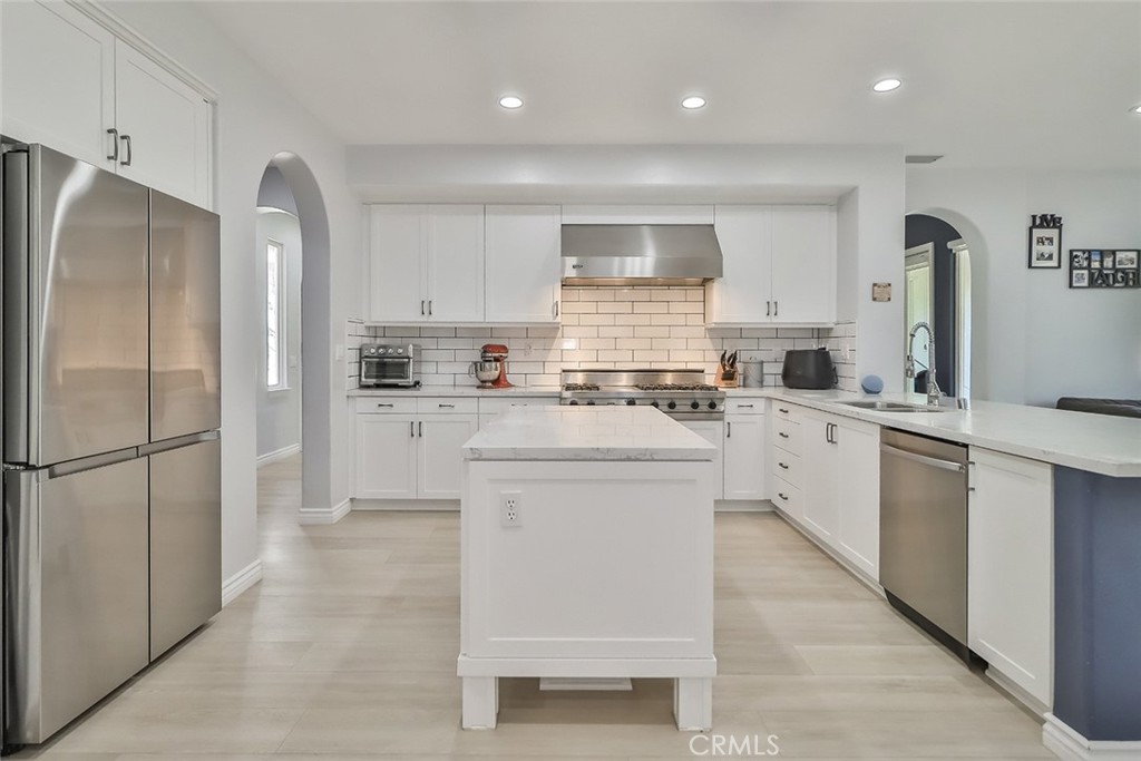 5421 Moonshadow Street Simi Valley, CA 93063 - Photo 19 of 56 a kitchen with white cabinets and stainless steel appliances