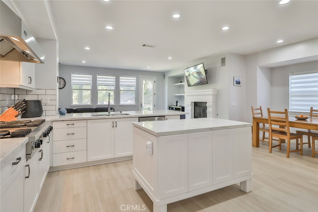 5421 Moonshadow Street Simi Valley, CA 93063 - Photo 24 of 56 a kitchen with kitchen island granite countertop lots of white cabinets and stainless steel appliances