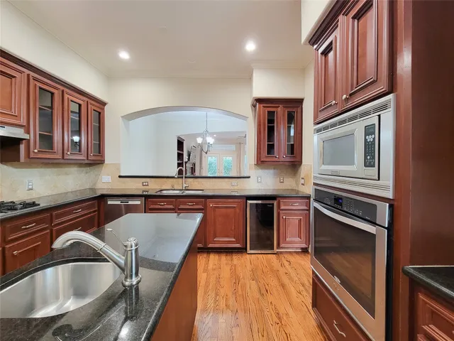 a view of a livingroom with wooden floor a ceiling fan and windows