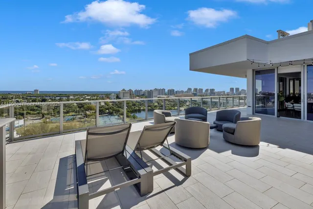 a view of roof deck with couches and sky view