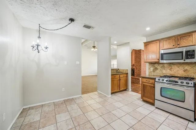 a kitchen with stainless steel appliances granite countertop a refrigerator a stove and a sink