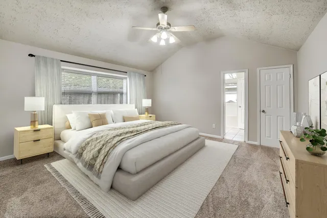 a bedroom with a large bed and a chandelier