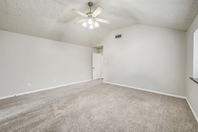 an empty room with a ceiling fan and a window