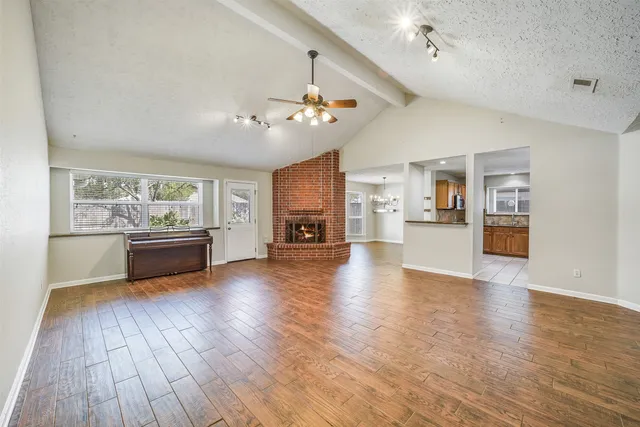 a living room with furniture wooden floor and kitchen view