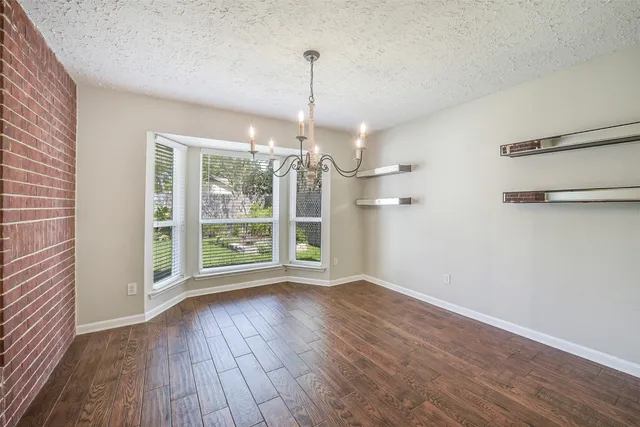 a view of a room with wooden floor fan and windows