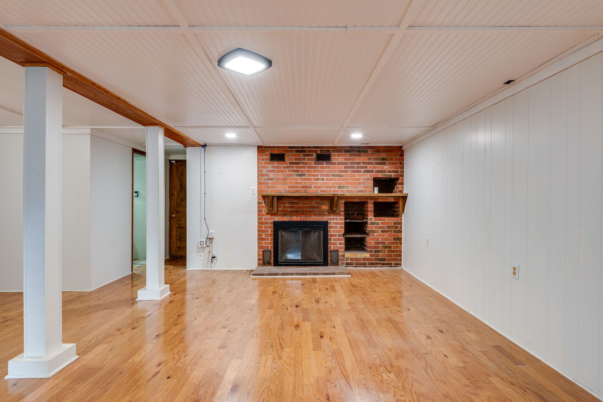 1021 Mitchell Road Nashville, TN 37206 - Photo 22 of 29 a view of an empty room with wooden floor fireplace and a window