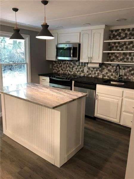 245 Hilton Way Canton, GA 30114 - Photo 5 of 13 a kitchen with stainless steel appliances granite countertop a sink a stove and a wooden floors