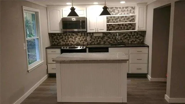 a kitchen with stainless steel appliances granite countertop a sink and a stove