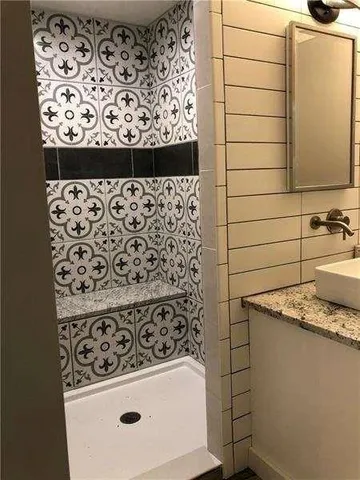 a bathroom with a granite countertop sink and a mirror