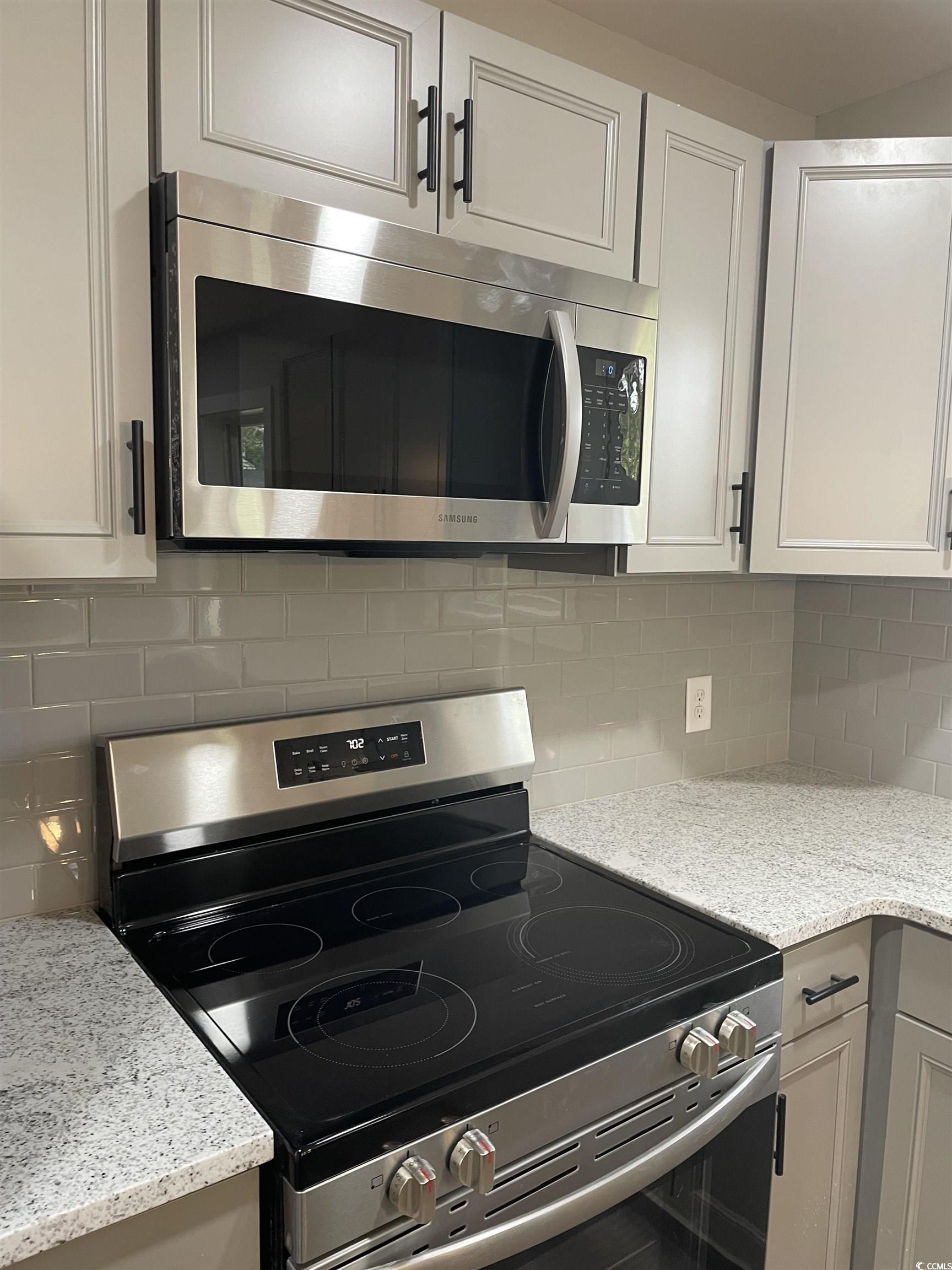 1712 Singleton Street Conway, SC 29527 - Photo 35 of 40 Kitchen featuring appliances with stainless steel finishes, light stone counters, backsplash, and white cabinets