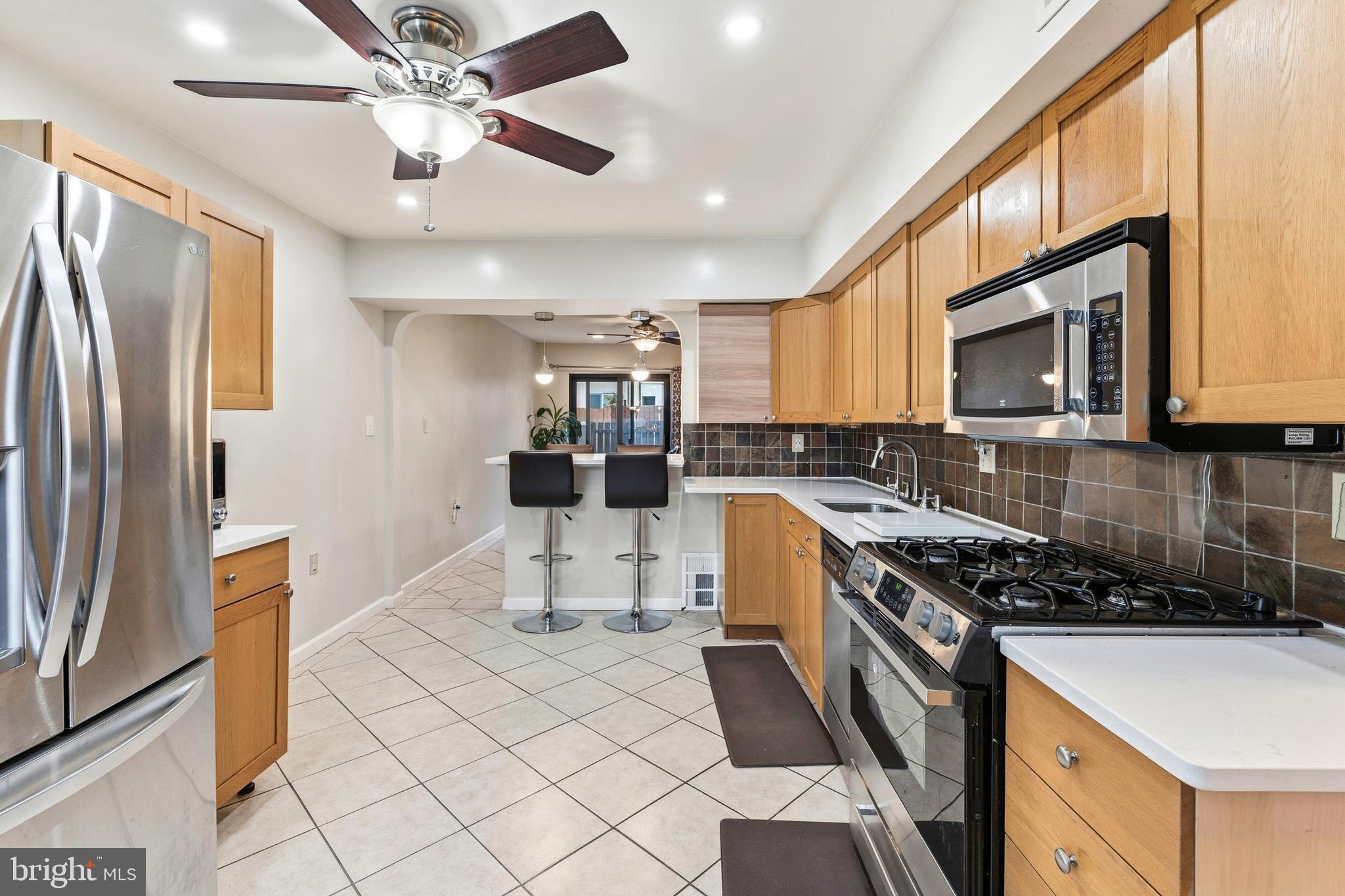 7641 Laytonia Drive Gaithersburg, MD 20877 - Photo 7 of 31 a kitchen with stainless steel appliances granite countertop a stove top oven a sink a dining table and chairs