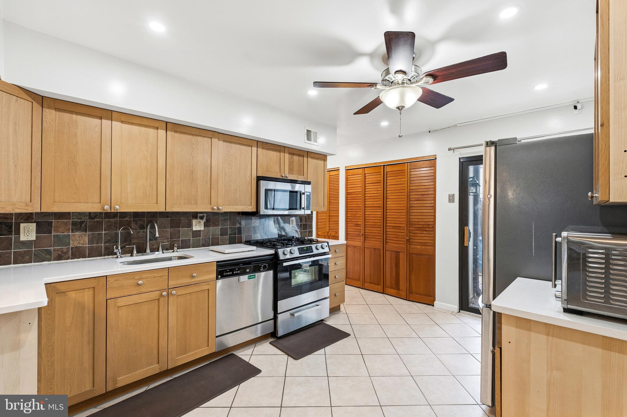 7641 Laytonia Drive Gaithersburg, MD 20877 - Photo 10 of 31 a kitchen with a sink a stove cabinets and stainless steel appliances