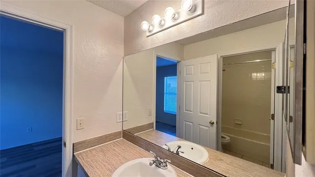 a bathroom with a tub shower vanity and a sink