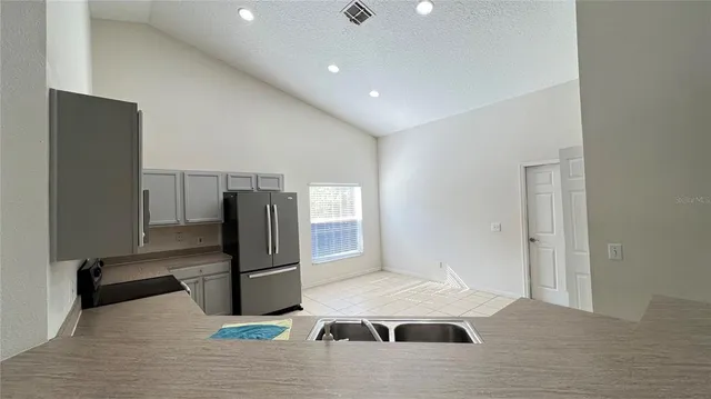 a kitchen with a refrigerator an oven and cabinets