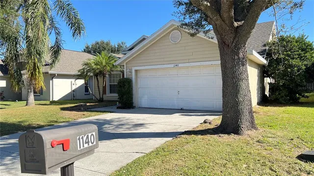 a view of a house with backyard and trees