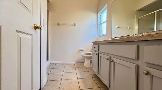 a bathroom with a granite countertop sink a toilet a mirror and shower
