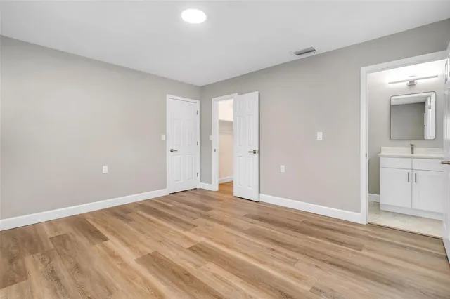 a view of an empty room and window and wooden floor