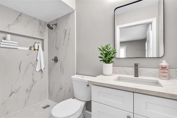 a bathroom with a sink a toilet and shower