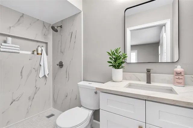 a bathroom with a sink a toilet and shower