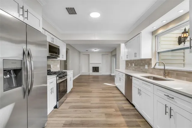 a large kitchen with kitchen island a sink stainless steel appliances and cabinets