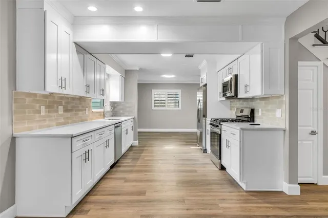 a large kitchen with stainless steel appliances granite countertop a stove and a sink