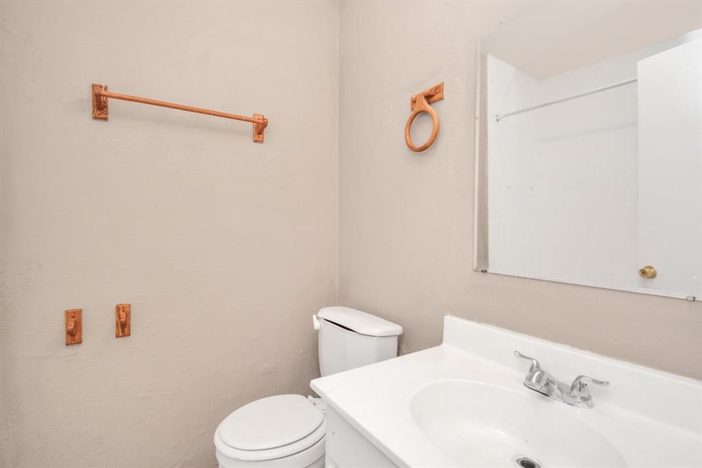 4803 Beechaven Street Houston, TX 77053 - Photo 11 of 30 a white toilet sitting next to a bathroom sink