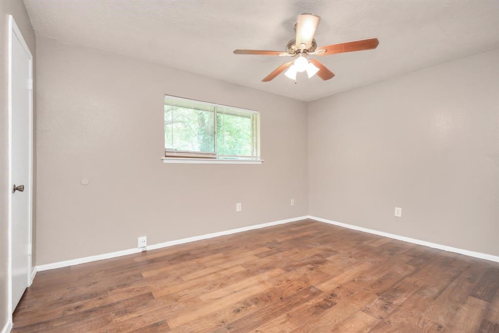 4803 Beechaven Street Houston, TX 77053 - Photo 15 of 30 an empty room with wooden floor fan and windows
