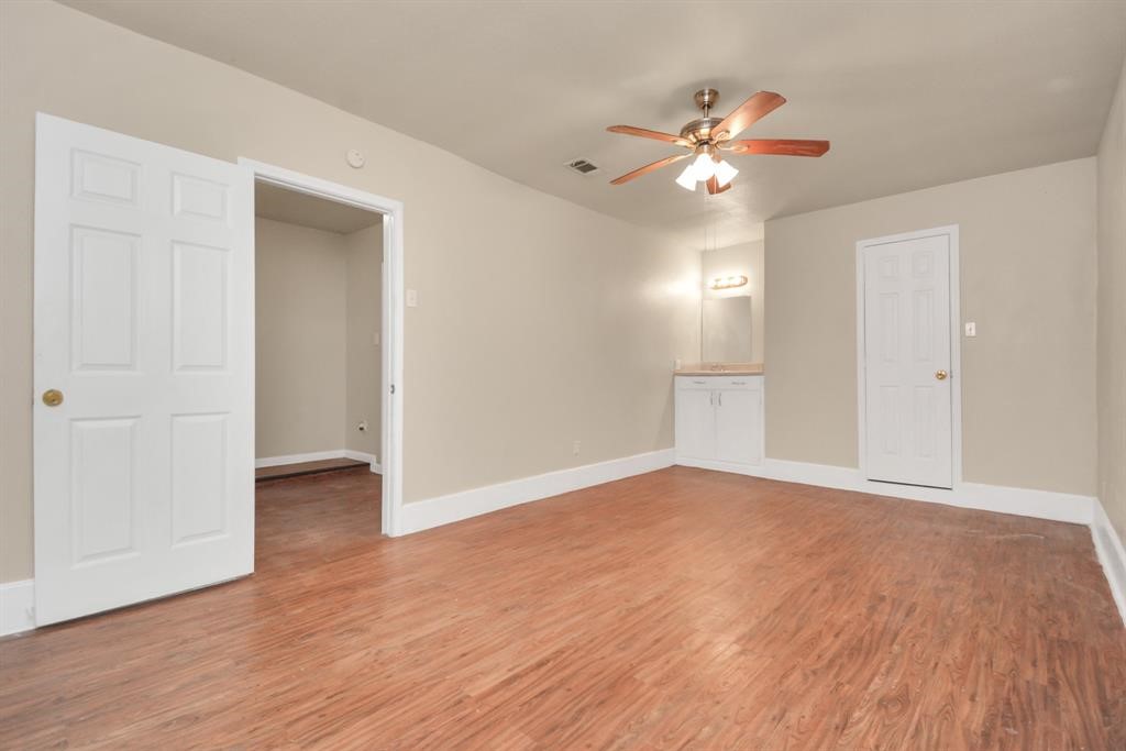 4803 Beechaven Street Houston, TX 77053 - Photo 23 of 30 a view of an empty room with wooden floor and a ceiling fan