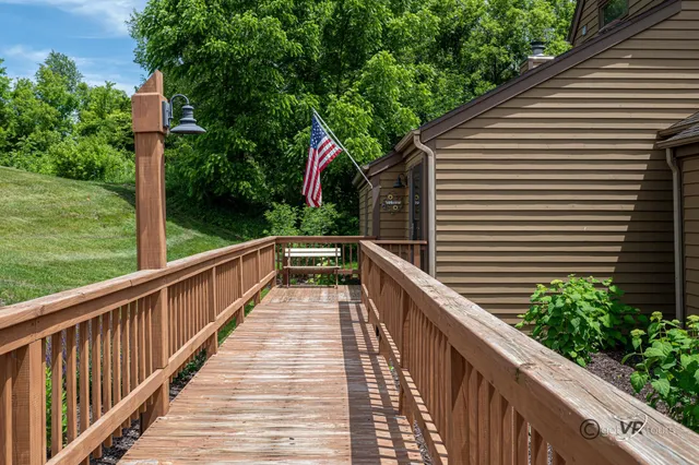 a balcony with wooden floor and trees in the background