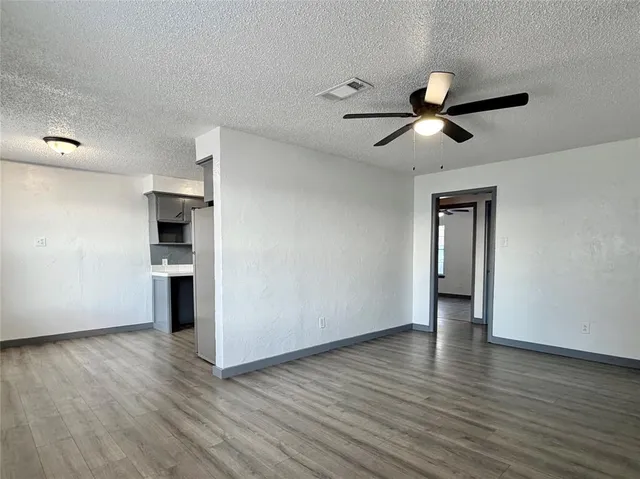 a view of empty room with wooden floor and window