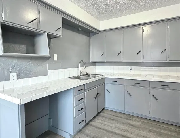 a kitchen with a sink cabinets and a wooden floor