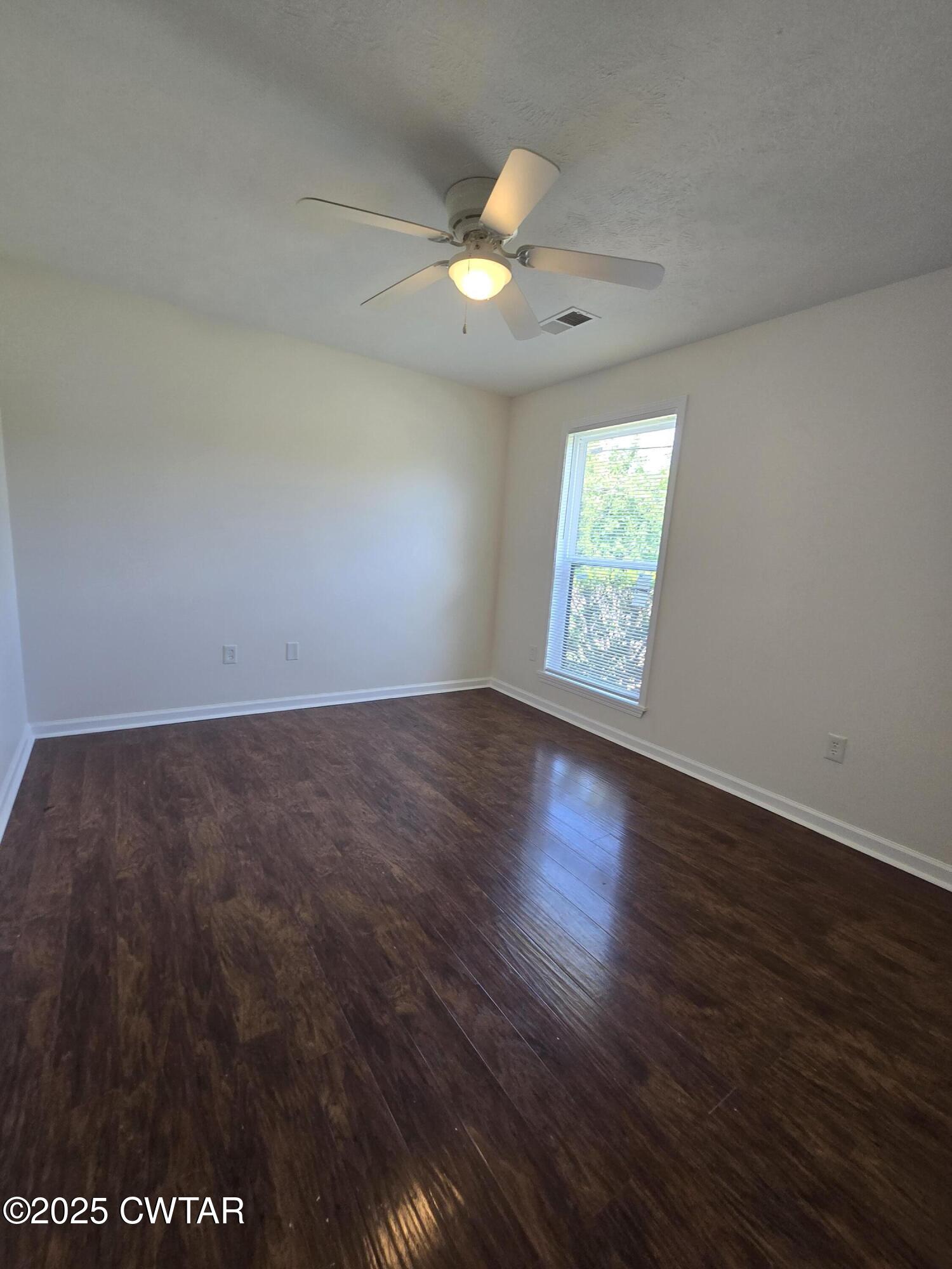 494 Mifflin Road Jackson, TN 38301 - Photo 8 of 11 an empty room with wooden floor and windows