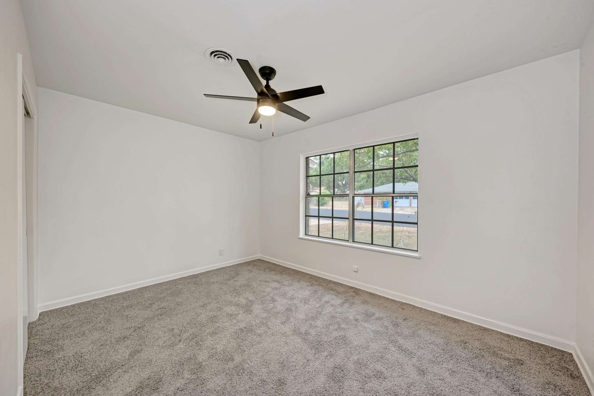 7804 Rutgers Avenue Austin, TX 78757 - Photo 13 of 32 Soft carpeting underfoot and a multi-pane window create a comfortable and inviting bedroom atmosphere.